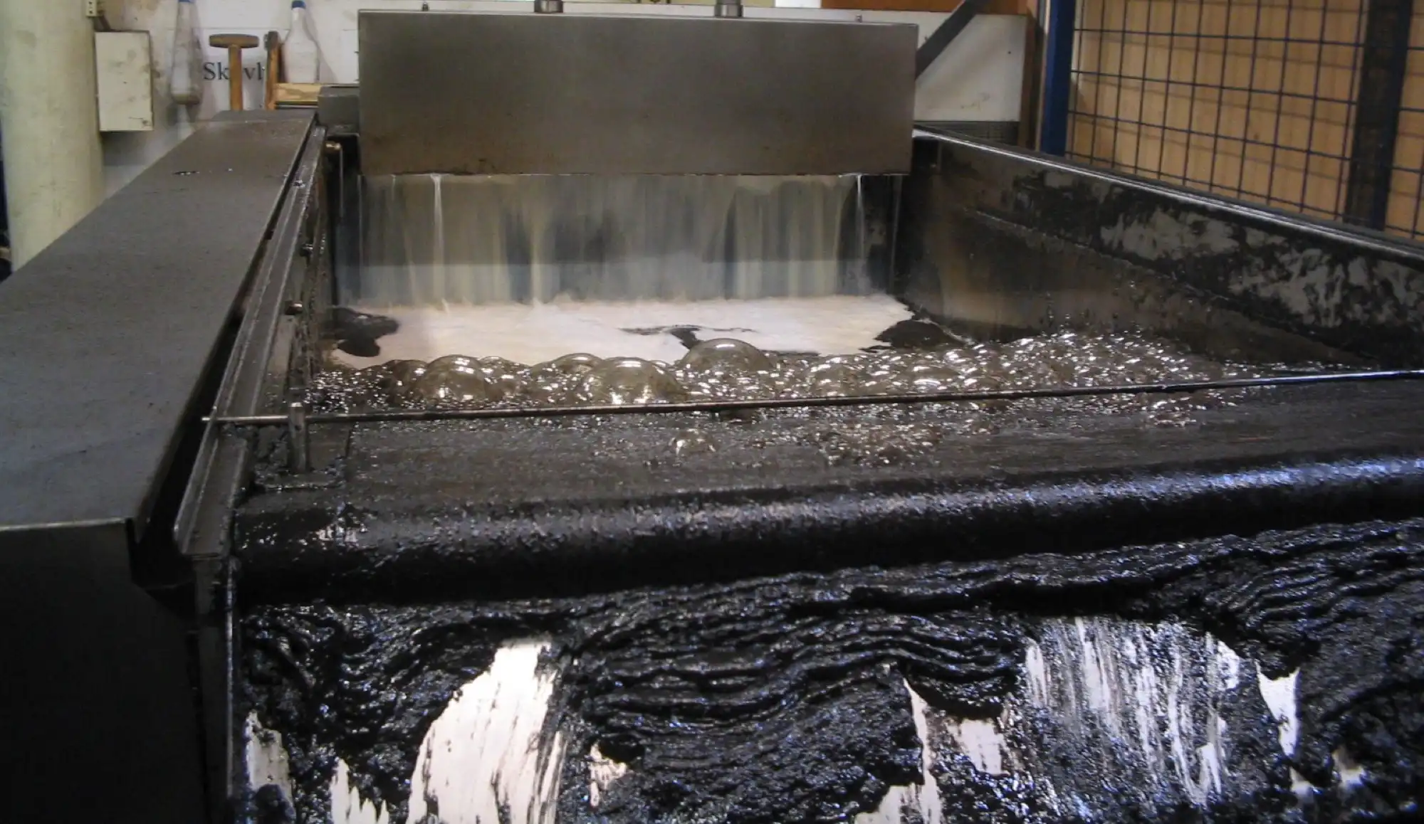 Belt filter full of black sludge from a process fluid