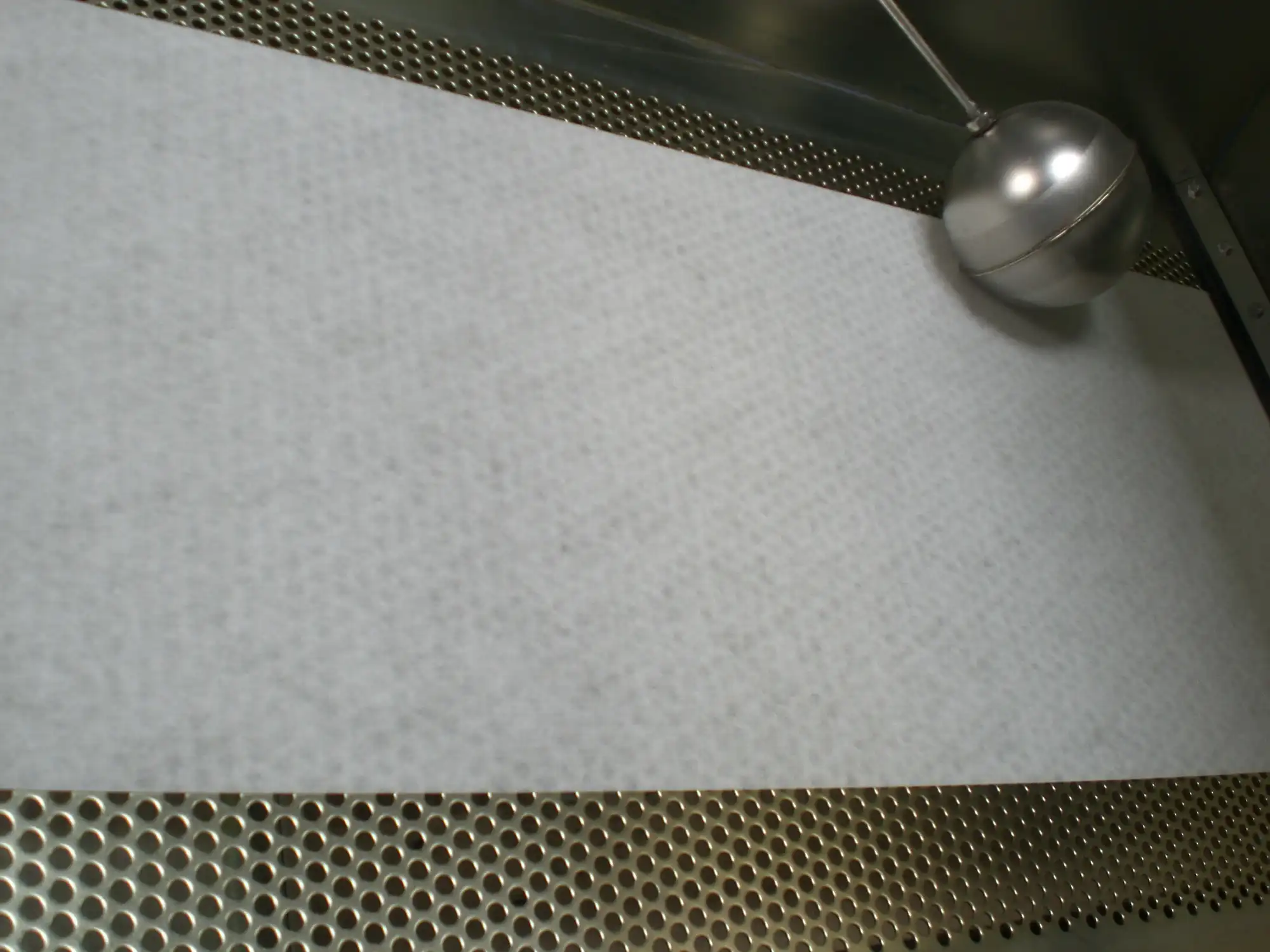 White filter paper on a perforated plate in a belt filter